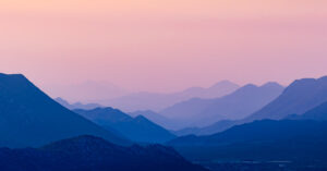 Layers of mountains in the early morning magenta light.